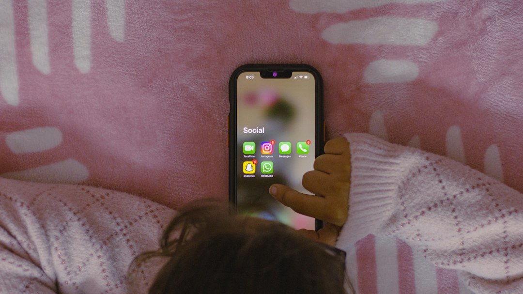 Slang on different apps - A person laying in bed holding a cell phone